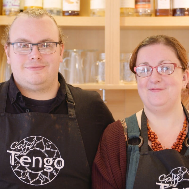 Man and woman in a cafe wearing aprons with the word Tengo on them