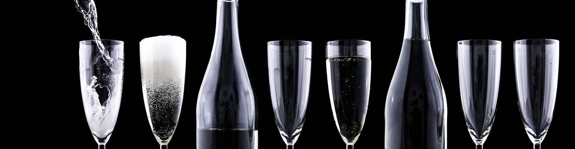 champagne flutes and bottles with black background