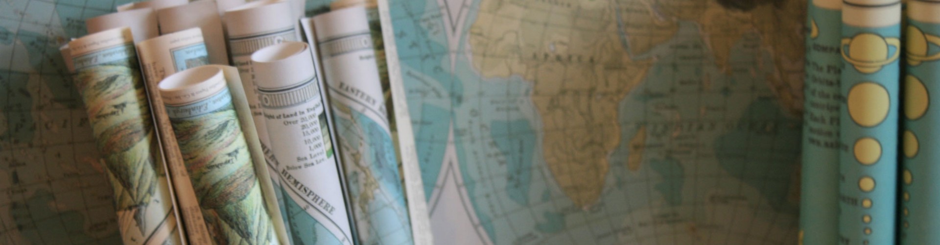 rolled up maps in front of a map of the world