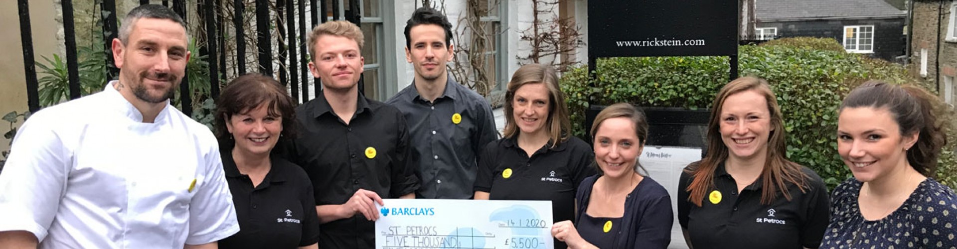7 st petroc's bistro staff posing with a large cheque
