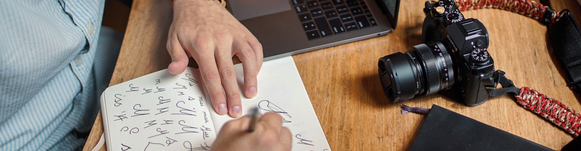 man drawing with camera and laptop on table 