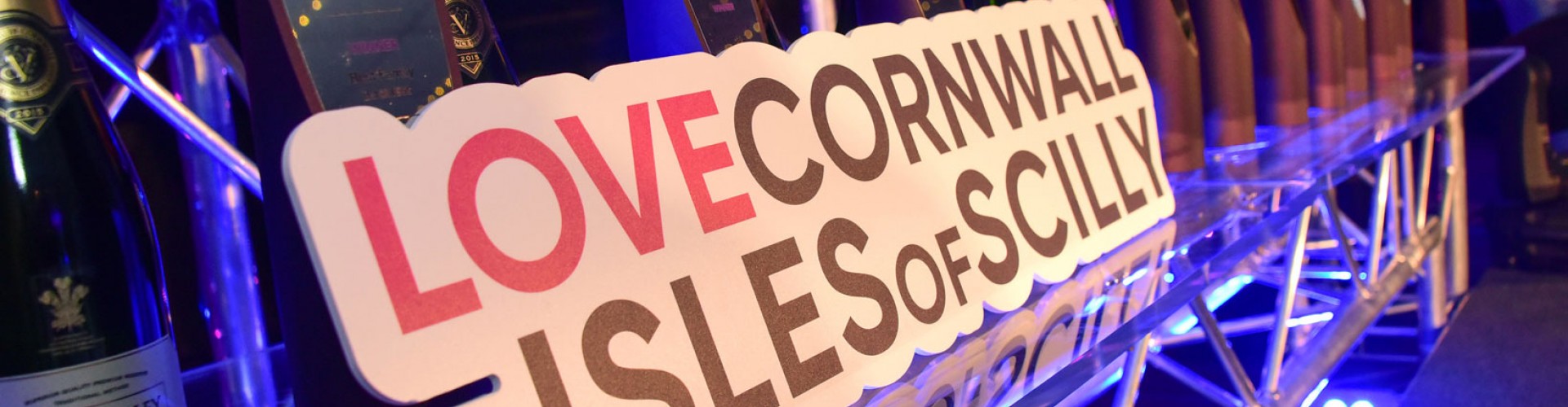 Cornwall Business Awards trophies and champagne with Love Cornwall and Isles of Scilly sign