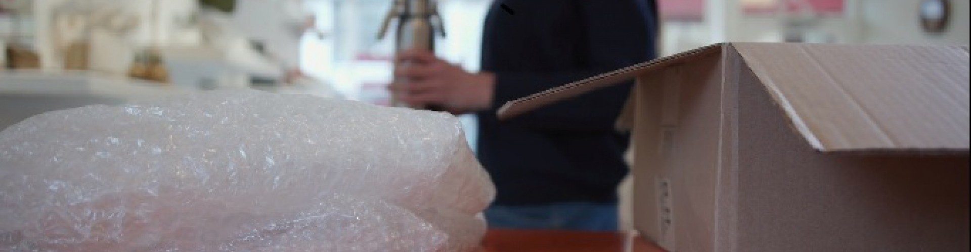 bubblewrap and packaging box with person in background. packshare