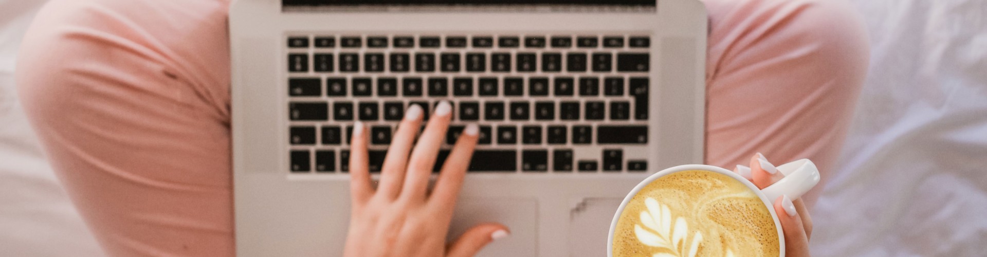 woman using laptop drinking coffee