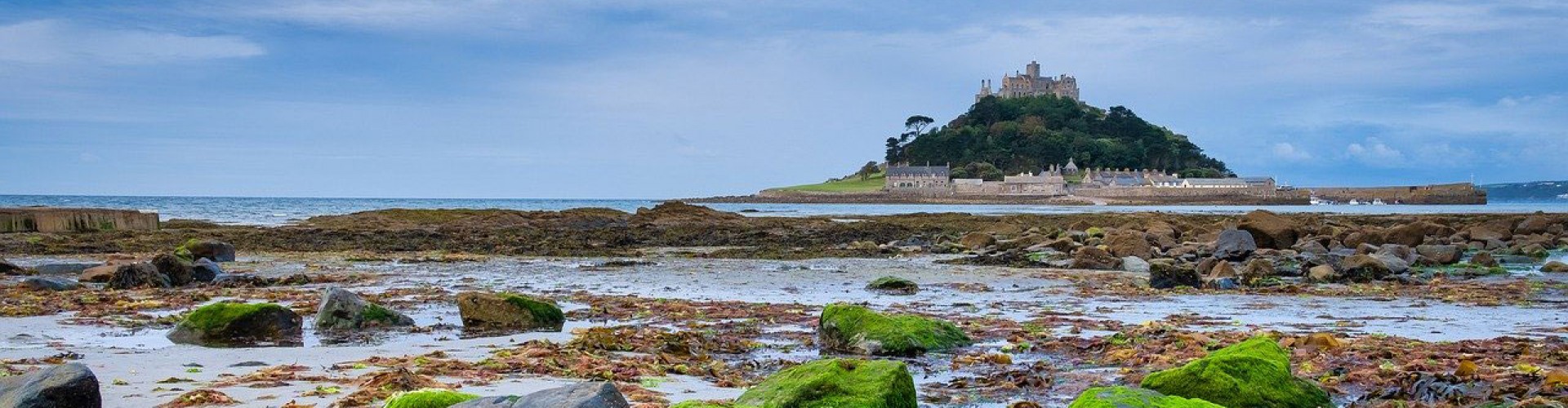 St Michael's Mount Cornwall from a distance across a rocky beach