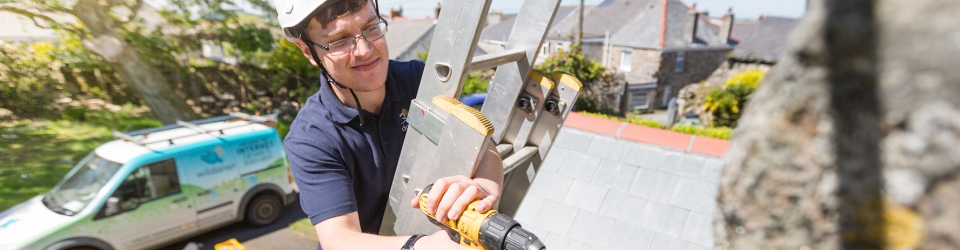 Image of man up a ladder installing fibre broadband