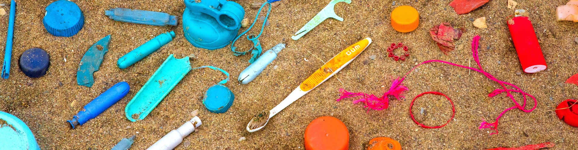 waste plastics arranged by colour on beach