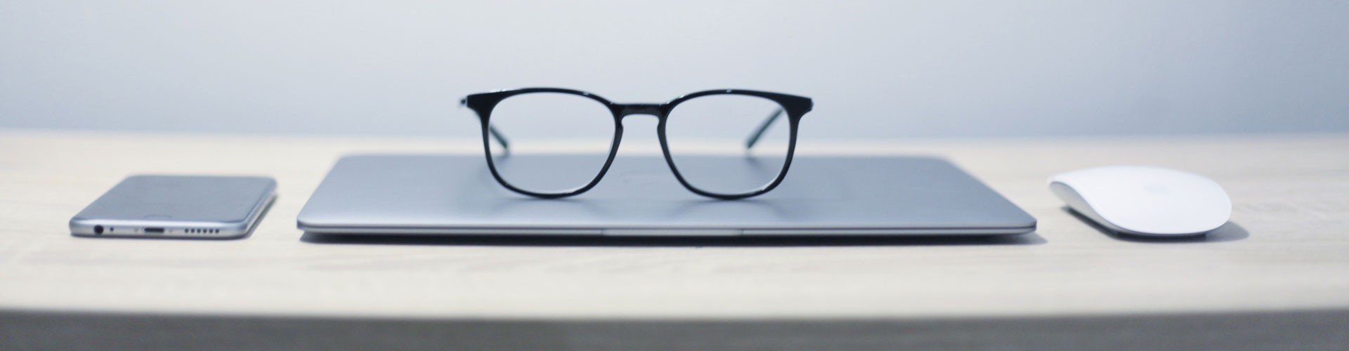 pair of glasses on top of closed laptop