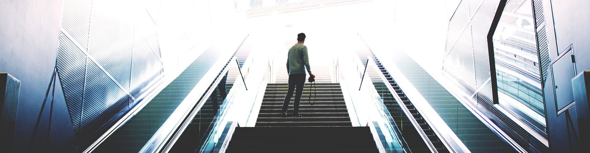 man ascending escalator