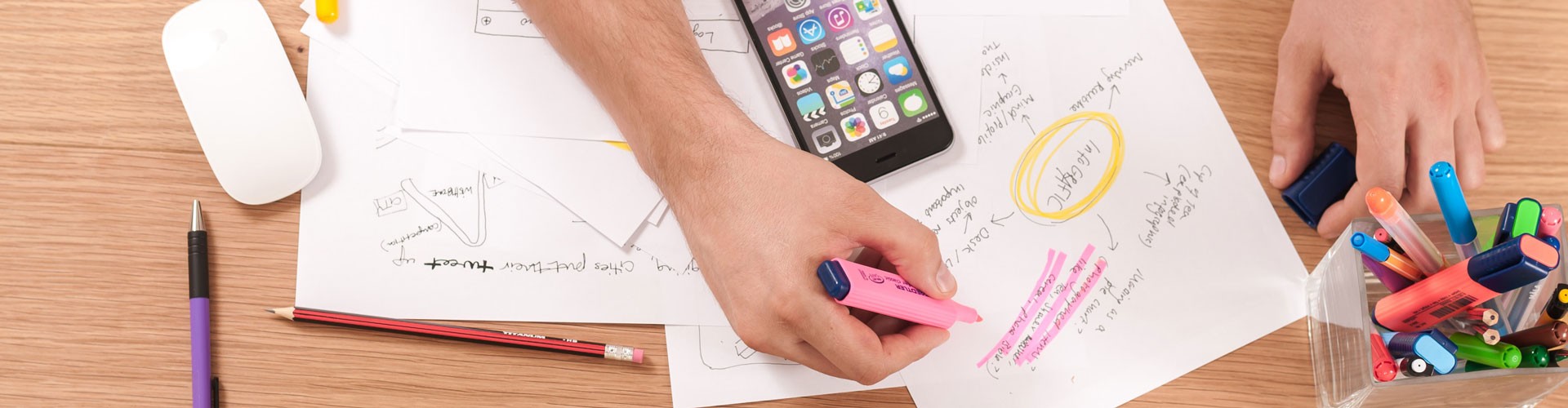 papers spread across table with hand highlighting information