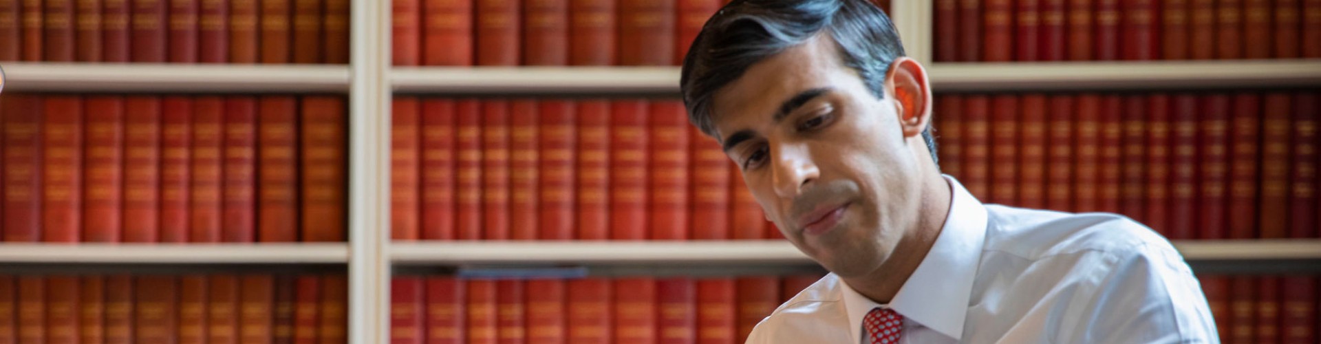Rishi Sunak in a library of leather bound red books