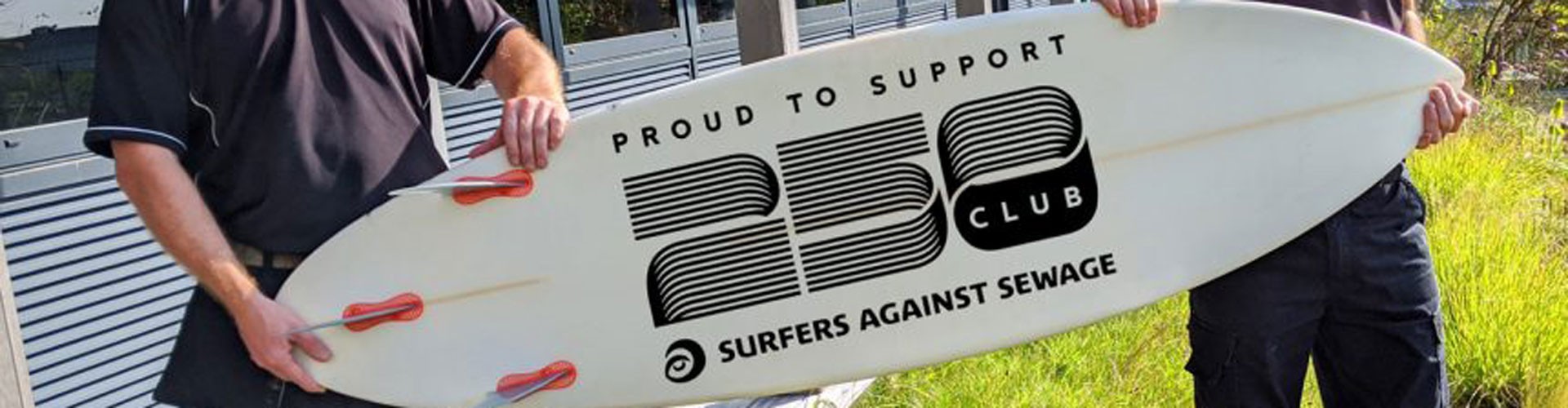 St Austell Printing Company employees holding SAS 250 surfboard
