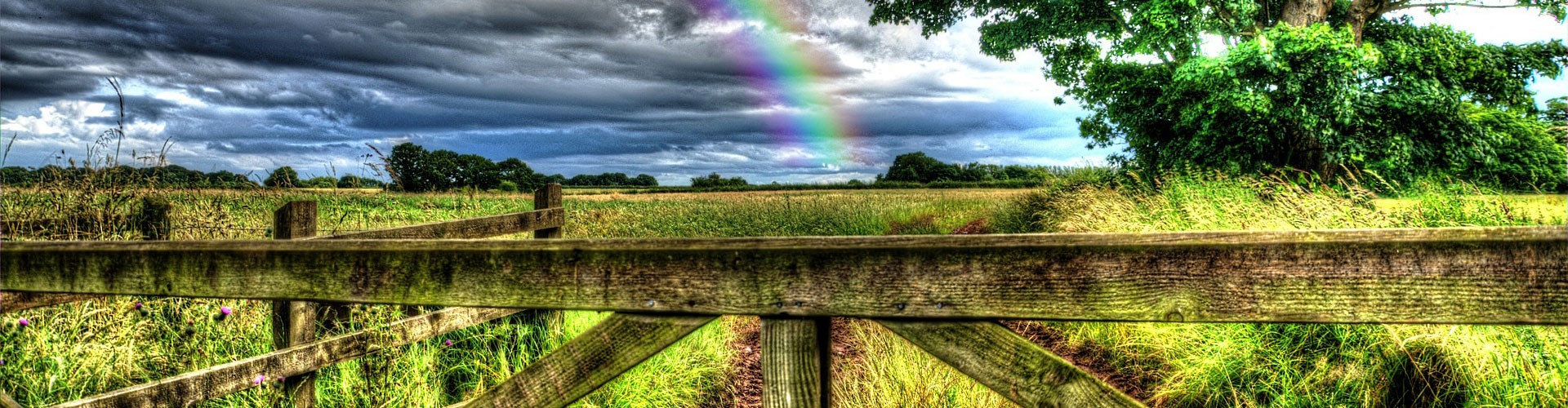 rainbow over gate in rural england