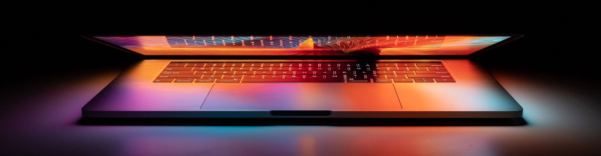 laptop slightly open with colourful light
