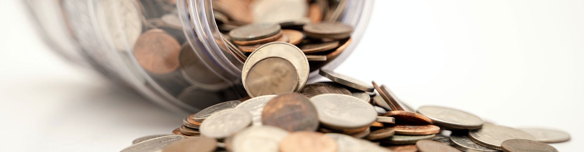 coins spilling out of glass jar