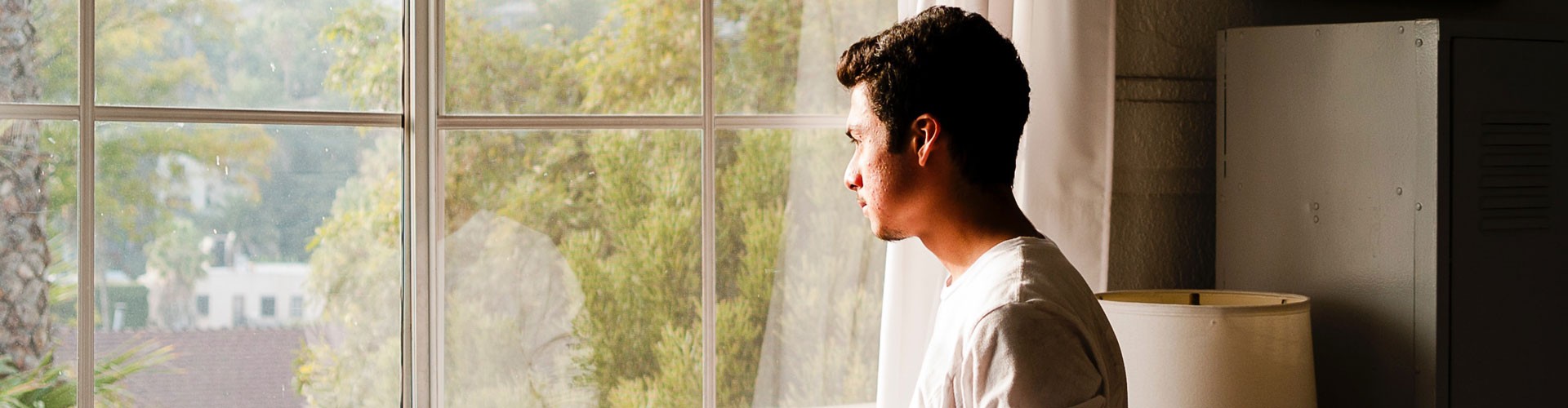 young man looking out of window