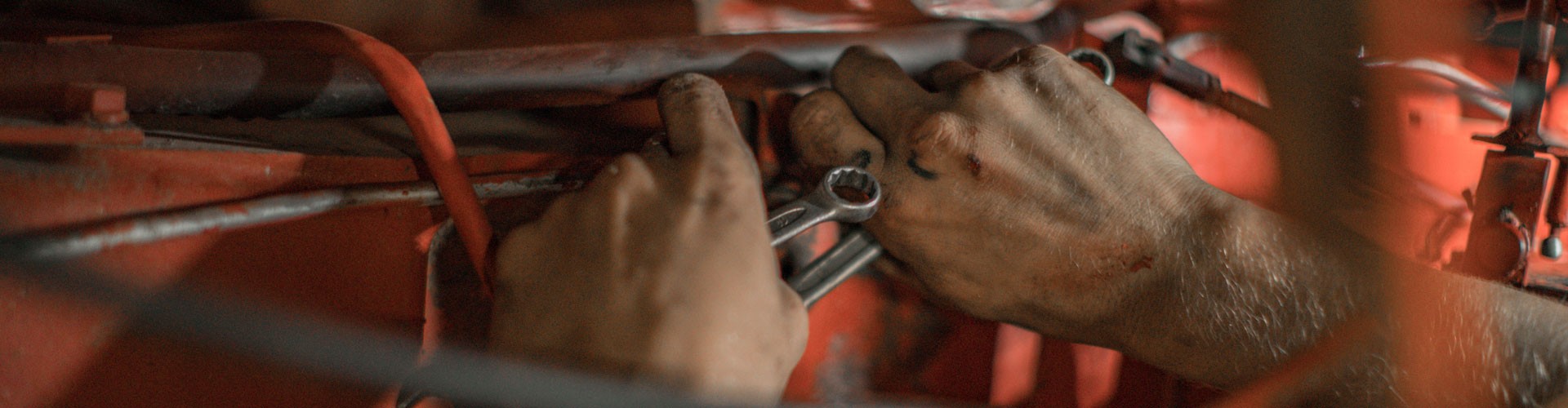 mechanic's hands working underneath a car