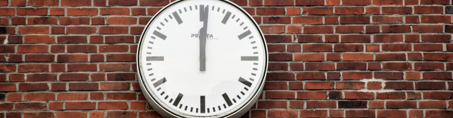 analogue clock on brick wall