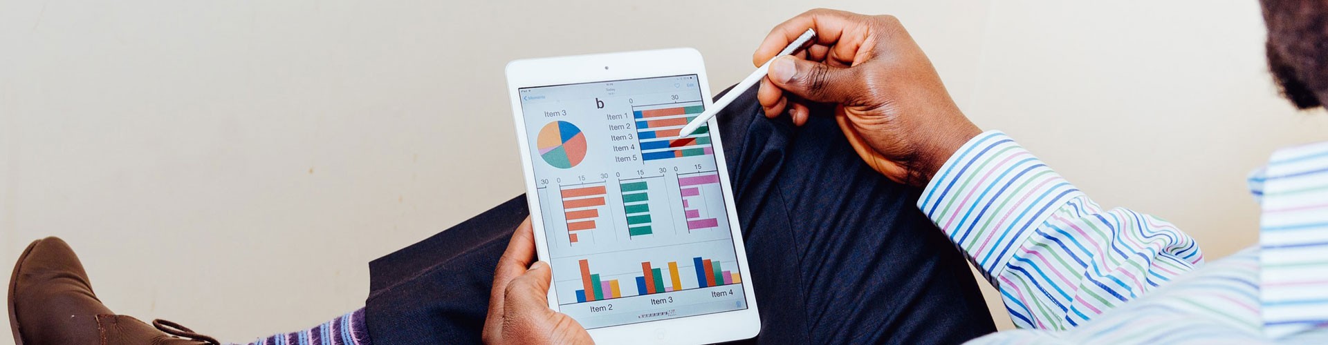 man looking at graphs on tablet