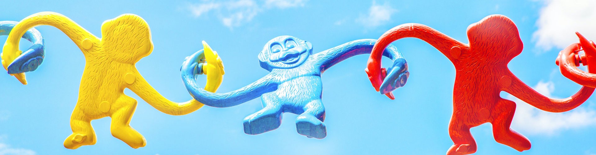 colourful plastic toy monkeys with arms linked