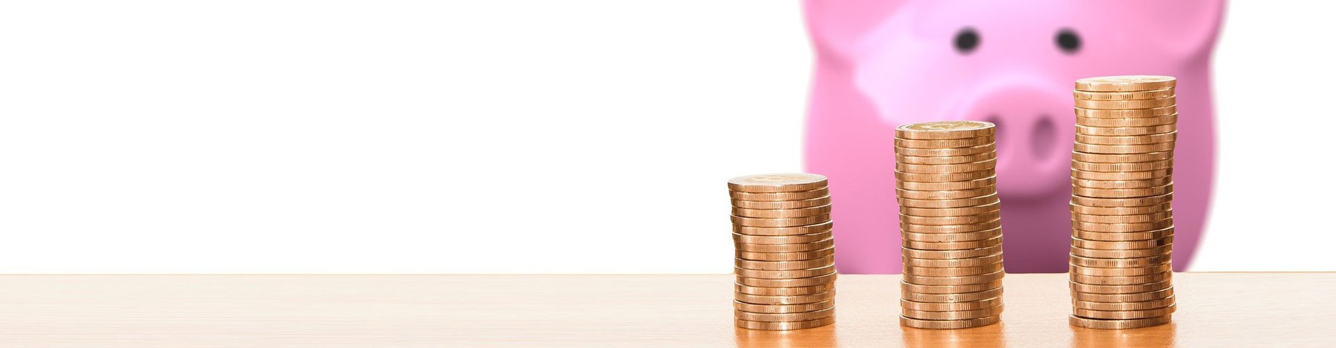pink piggy band behind stacks of coins