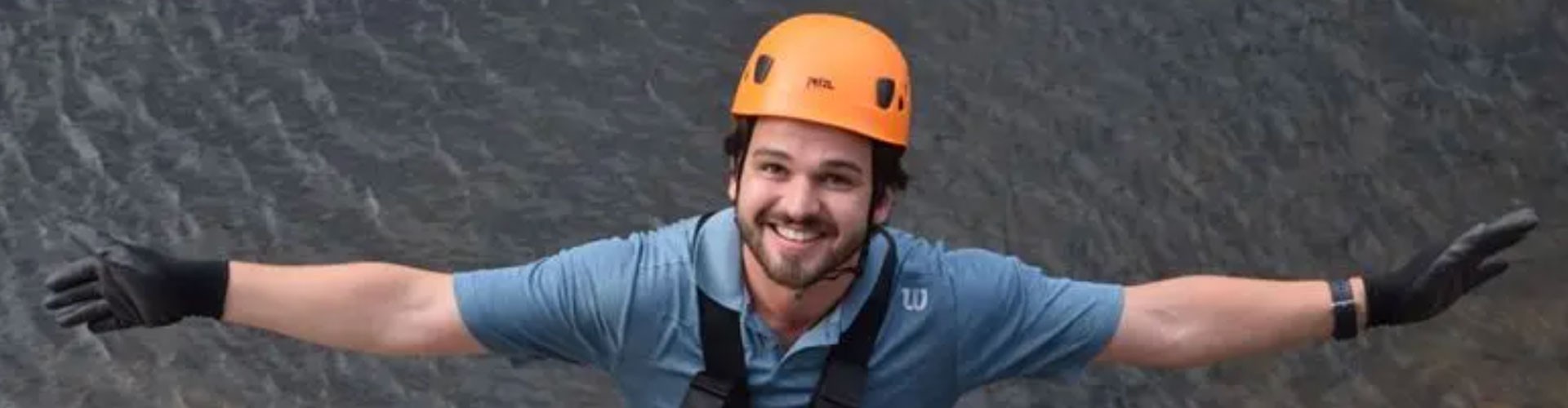 man in climbing helmet shot from above with water behind