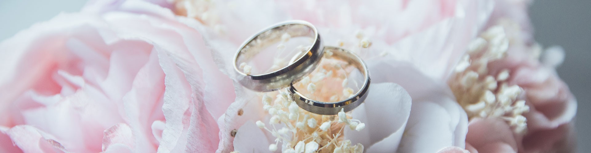 wedding rings on top of pink flower bouquet
