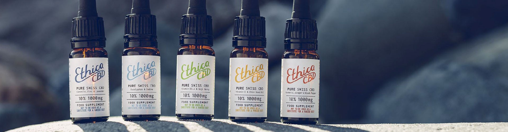 range of Ethica CBD bottles on a rock outside