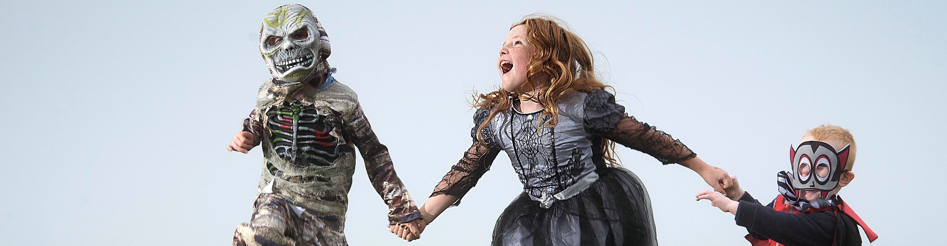 kids in halloween costumes skipping outdoors