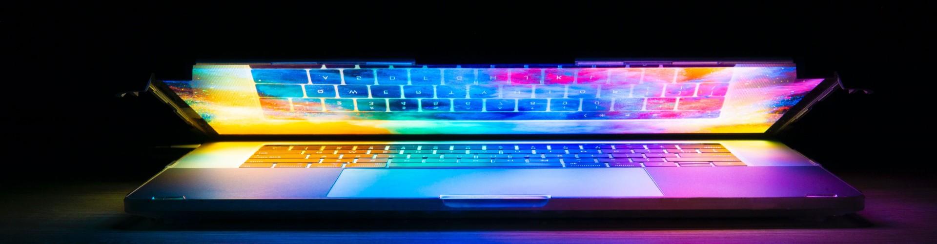 An opening laptop with rainbow colours
