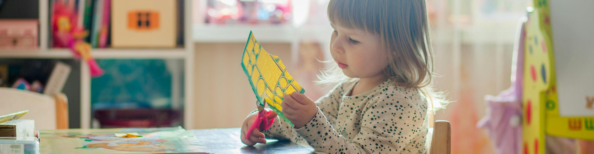 child cutting a piece of paper daycare
