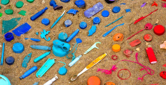 waste plastics arranged by colour on beach