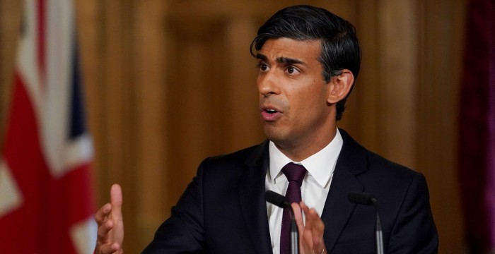 rishi sunak giving a speech with union jack behind