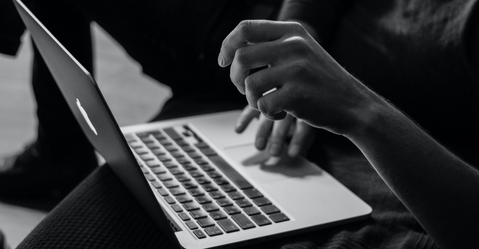 A person using a laptop in black and white