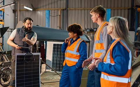 Group in hi vis watching person speak 