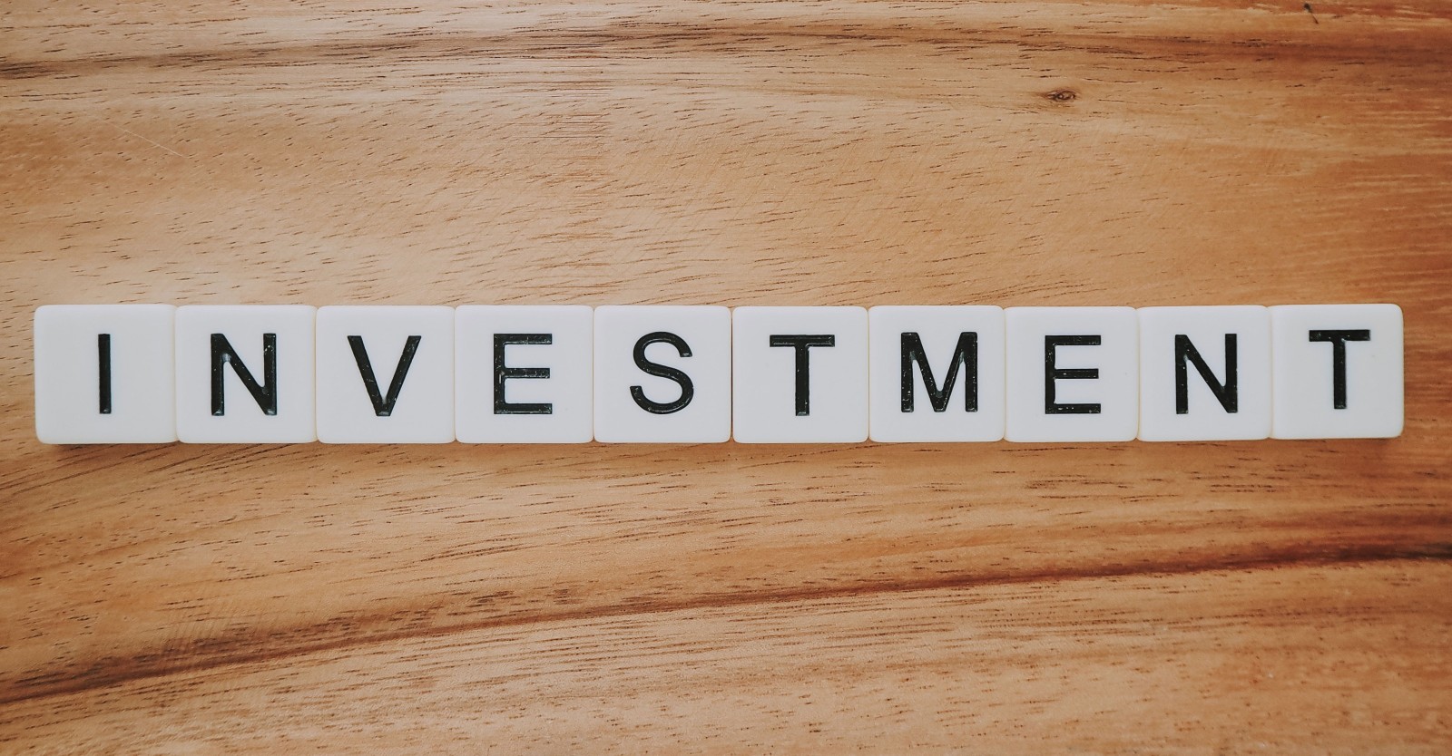 Scrabble tiles which read "INVESTMENT"