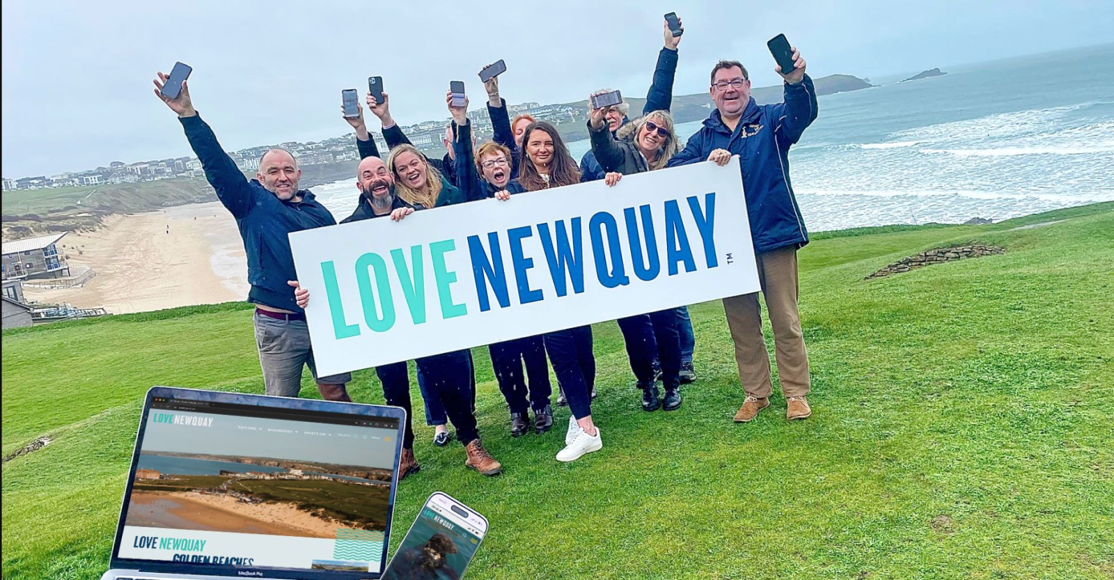 People holding a banner with the new branding: Love Newquay 