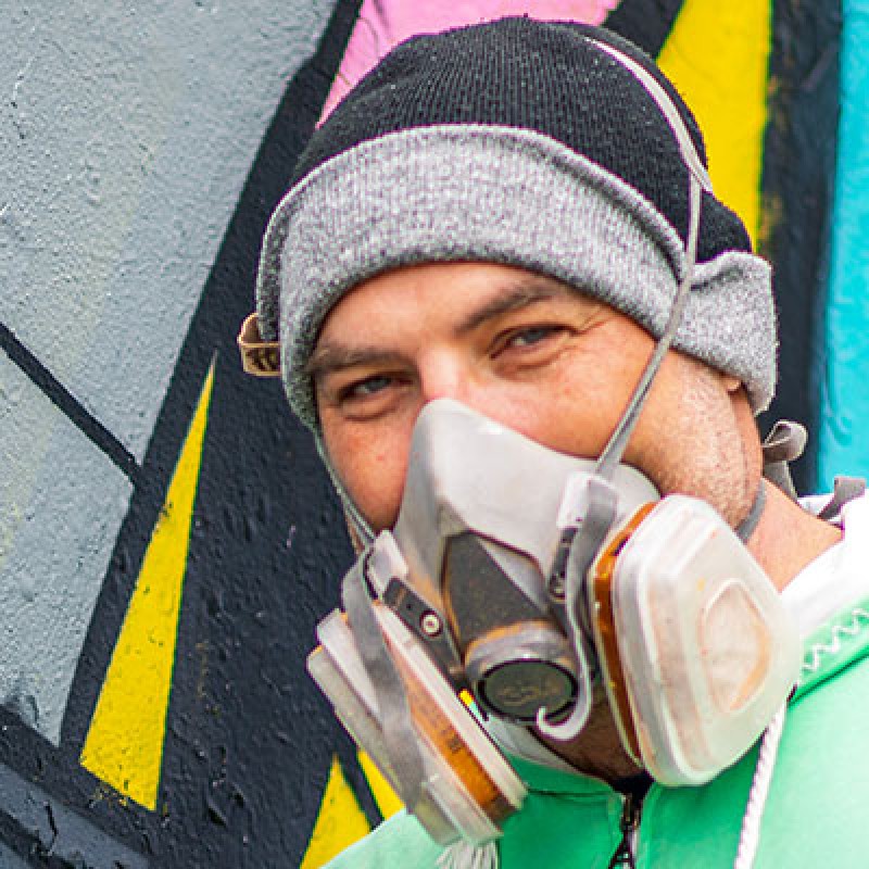 Brad with mask in front of artwork