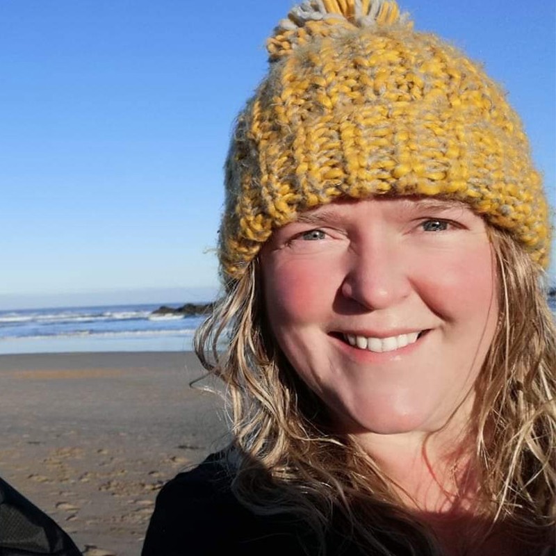 Tori Knight on beach wearing a bobble hat 